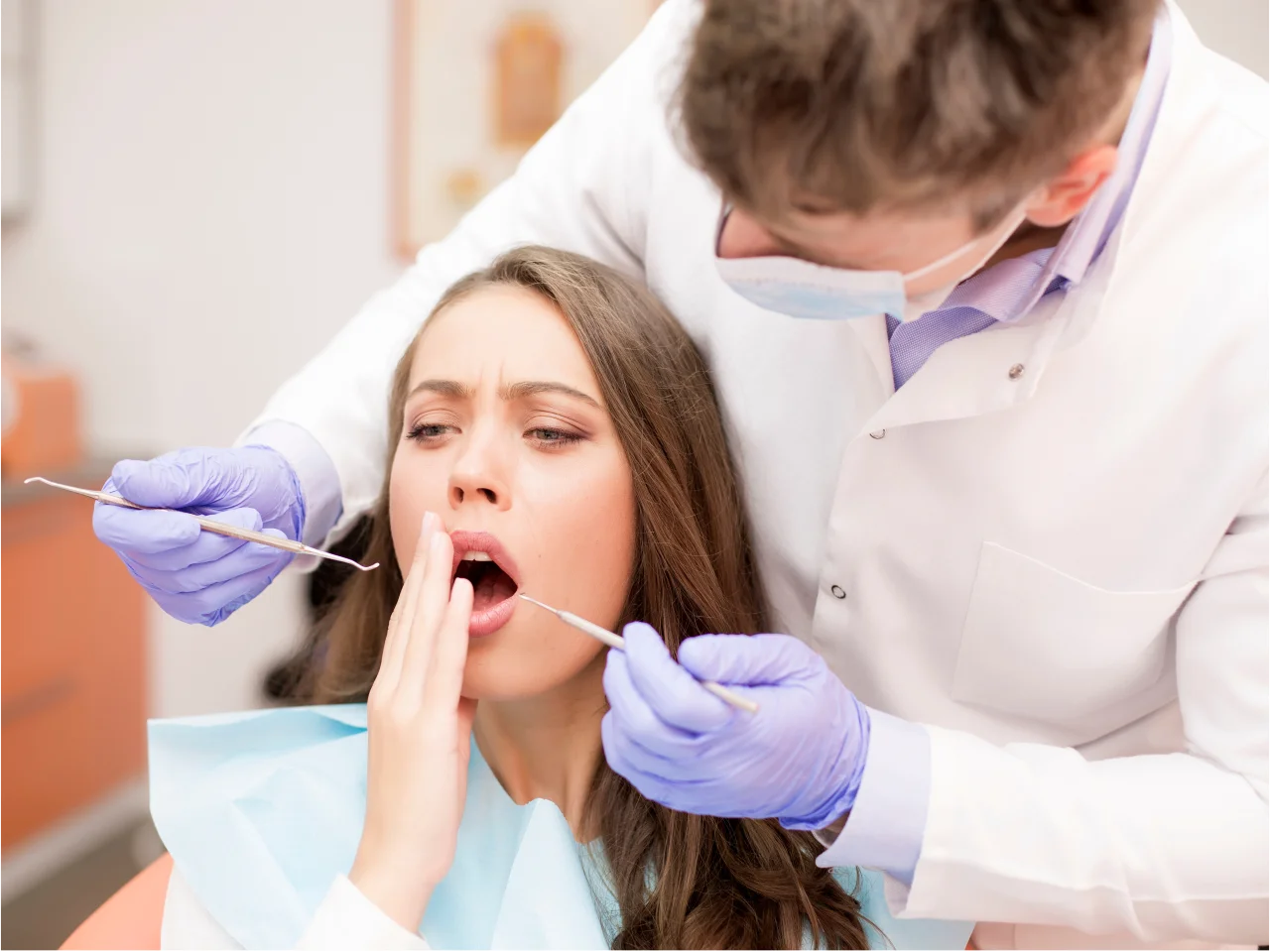Dentist examining patient's teeth during emergency dental visit