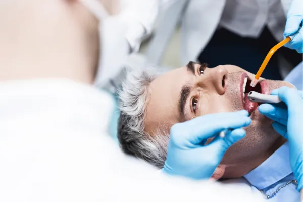 Dentist performing emergency root canal procedure on patient in dental chair