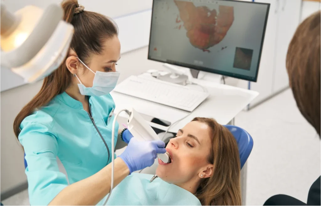 Dentist using digital iTero scanner on patient in dental chair with monitor displaying scan results