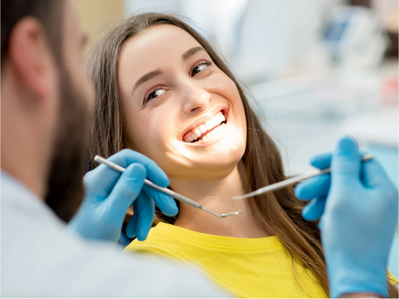 Smiling young woman in dental chair showing confident smile