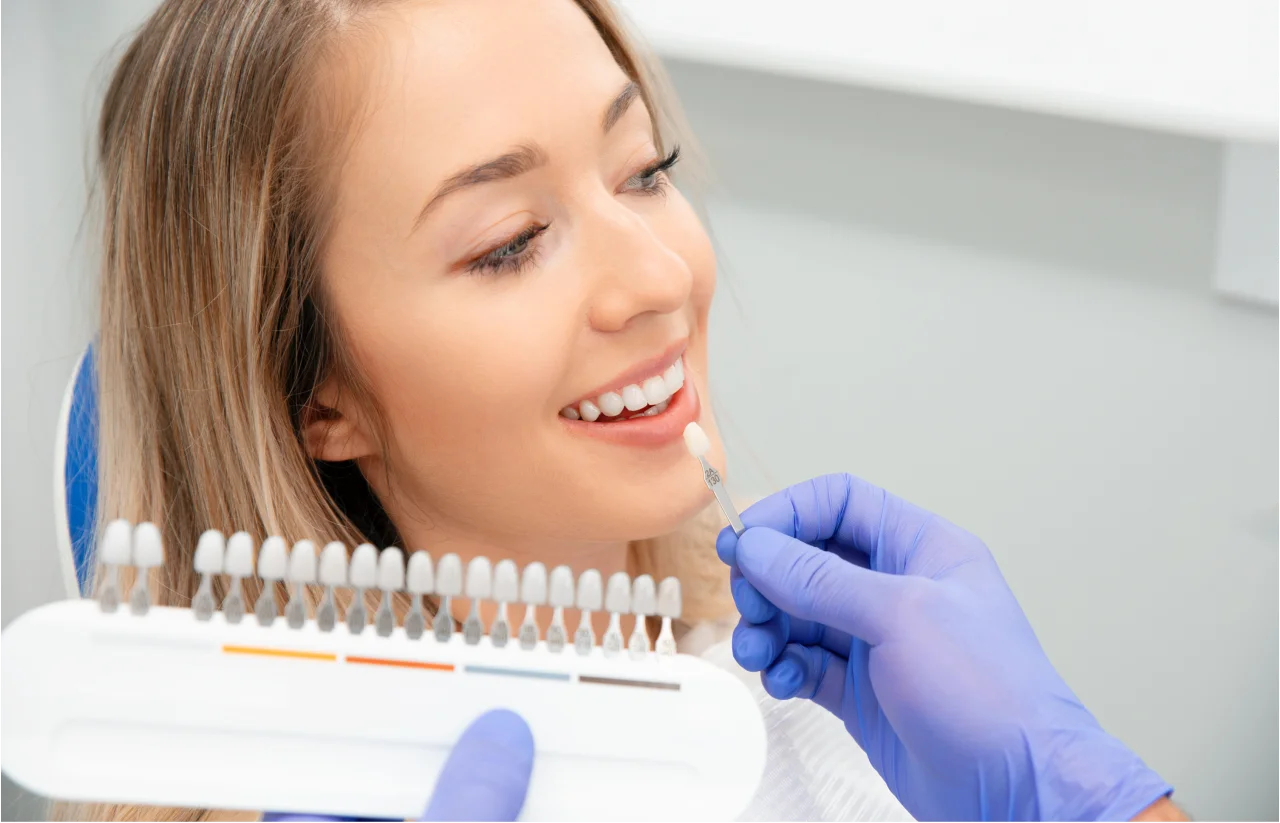 Woman smiling with dentist wearing blue gloves examining her teeth in dental office