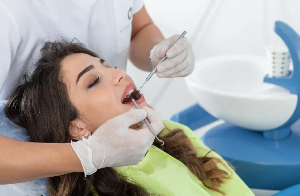 Woman in consultation with dentist holding digital tablet discussing dental treatment plan