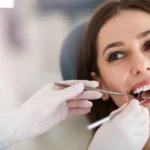 Woman looking in mirror examining her bright white teeth and smile
