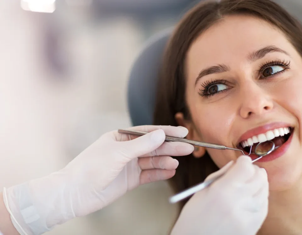 Woman looking in mirror examining her bright white teeth and smile