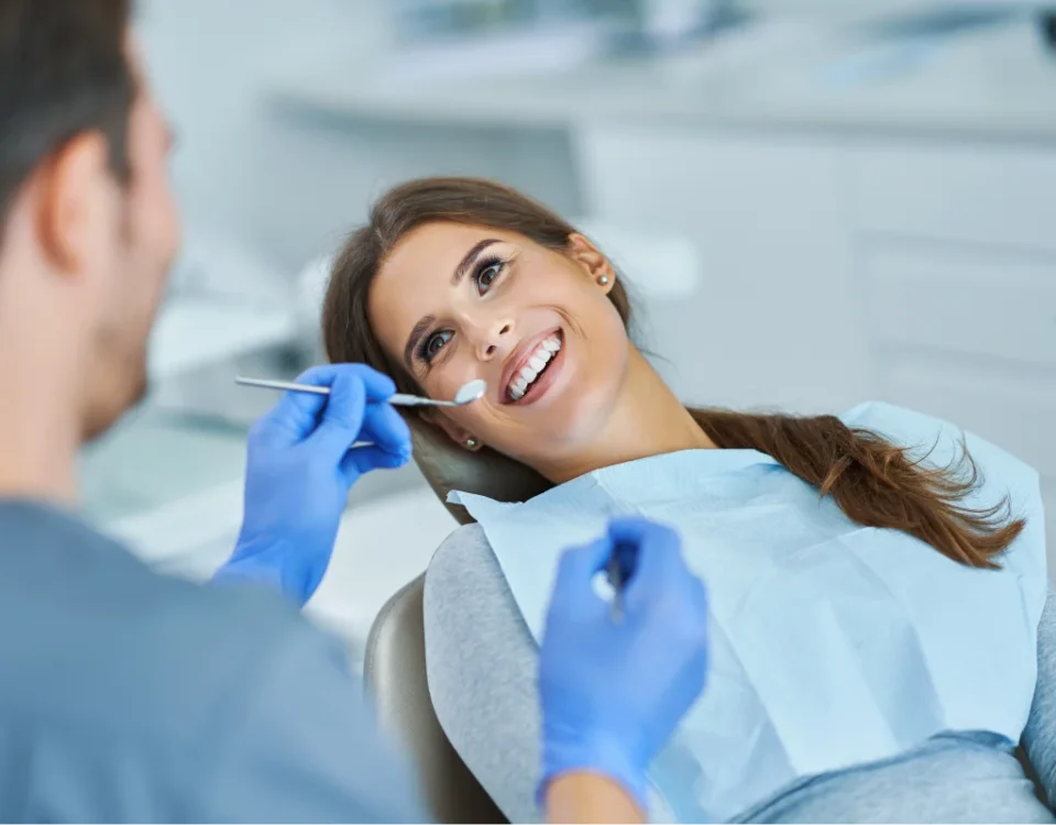 A smiling patient in a dental chair during a checkup for National Dentist's Day.
