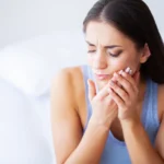 Woman experiencing severe tooth pain needing emergency dental procedures in Tacoma