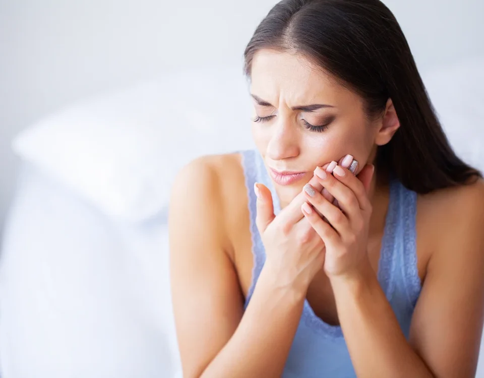 Woman experiencing severe tooth pain needing emergency dental procedures in Tacoma