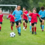 Children playing soccer on grassy field