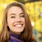 Young woman smiling outdoors representing National Smile Month 2026 oral health tips from Davis Dental Group in Tacoma