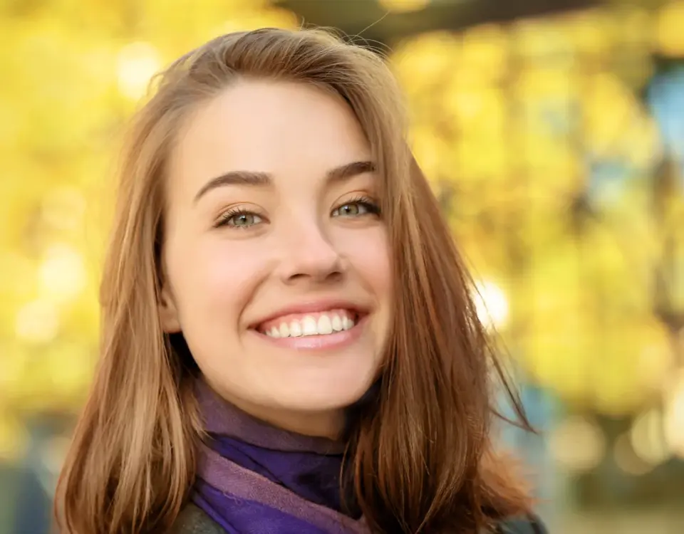 Young woman smiling outdoors representing National Smile Month 2026 oral health tips from Davis Dental Group in Tacoma