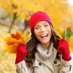 Woman smiling with autumn leaves representing autumn dental care tacoma at Davis Dental Group
