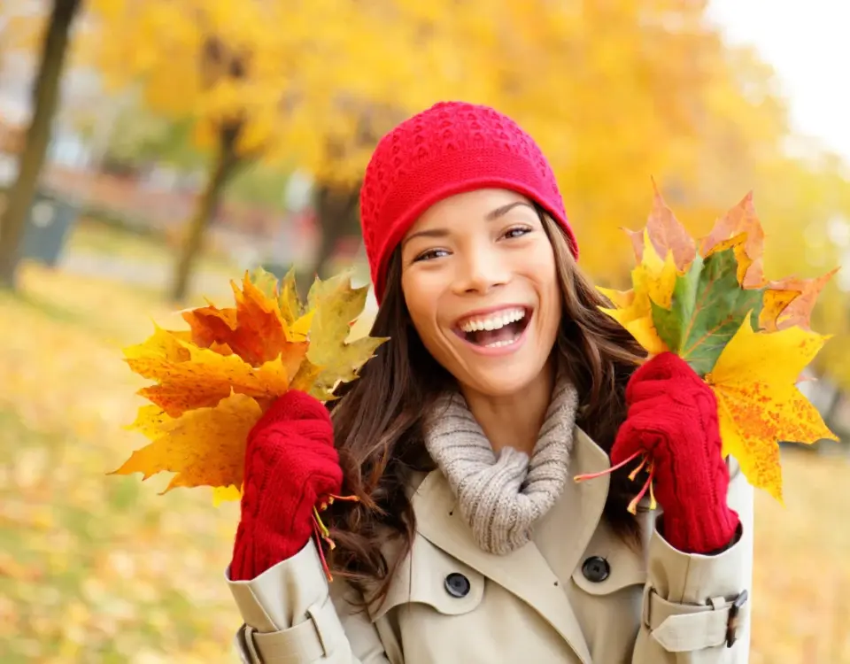 Woman smiling with autumn leaves representing autumn dental care tacoma at Davis Dental Group