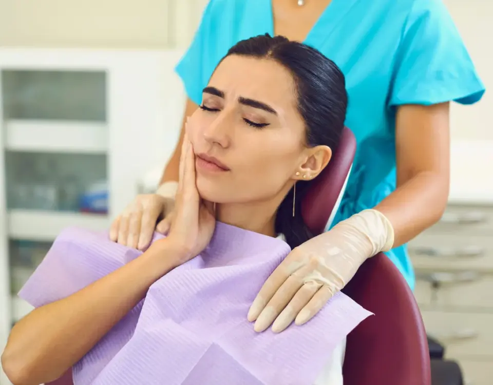 Patient holding jaw in pain at Davis Dental Group in Tacoma discussing tooth extractions and damaged tooth treatment options